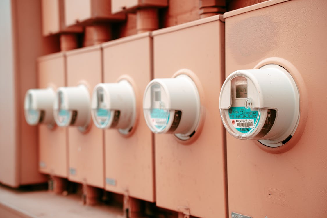 Row of electricity meters on a commercial building — the starting point for understanding how Australian energy efficiency schemes are funded